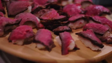 Tomahawk steak slice on a sushi rice laying on big wooden plate Stock Footage 244704492