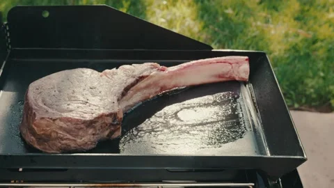 Tomahawk streak grilling outside on flat grill Stock Footage 276668944