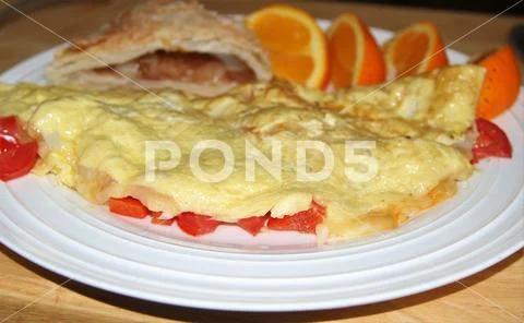 Tomato and cheese omelet with apple turnover and orange wedges Stock Photos