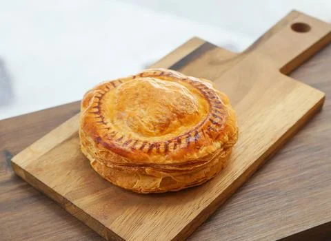 Tomato and Cheese Puff Pastry on Wooden Board side view of Savory Vegetaria.. Stock Photos