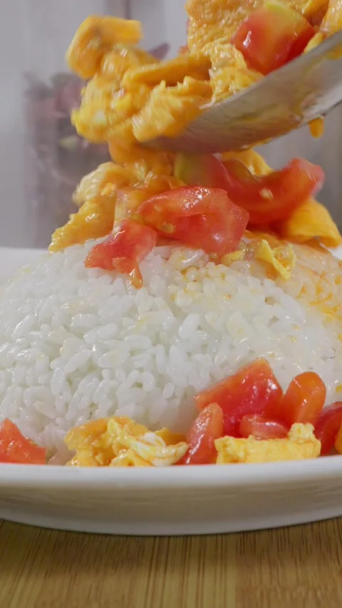 Tomato and egg stir-fry poured over steamed rice. Stock Footage 341306291