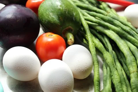 Tomato and eggs display with selective focus and fresh various raw organic veget Stock Photos