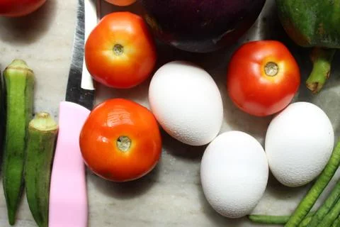 Tomato and eggs display with selective focus and fresh various raw organic veget 库存照片