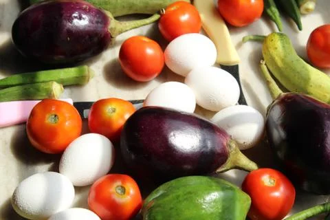 Tomato and eggs display with selective focus and fresh various raw organic veget 库存照片