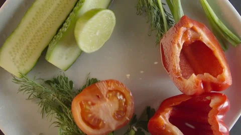Tomato and lime fall to the dish where vegetables Stock Footage 132082738
