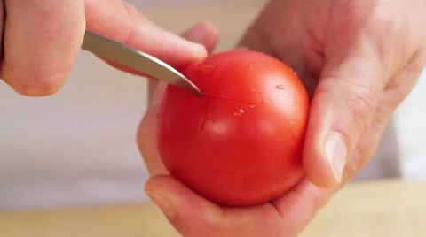 A tomato being scored with a cross Stock Footage 24673198