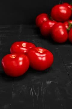 Tomato on a black background with realistic reflection and water drops. Fresh Stock Photos