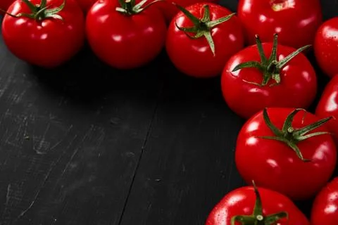 Tomato on a black background with realistic reflection and water drops. Fresh Stock Photos