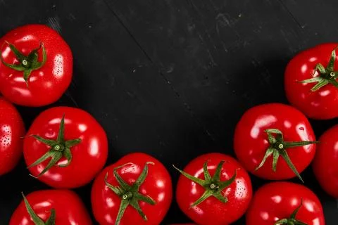 Tomato on a black background with realistic reflection and water drops. Fresh Stock Photos
