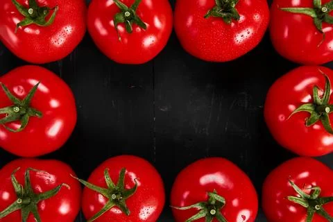 Tomato on a black background with realistic reflection and water drops. Fresh Stock Photos