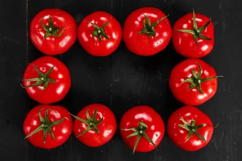 Tomato on a black background with realistic reflection and water drops. Fresh Stock Photos