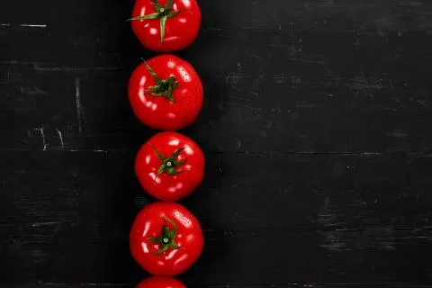 Tomato on a black background with realistic reflection and water drops. Fresh Stock Photos