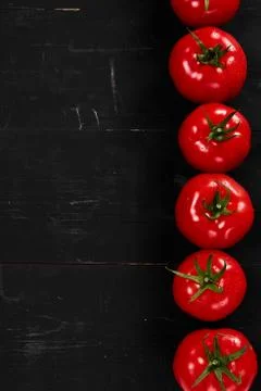 Tomato on a black background with realistic reflection and water drops. Fresh Stock Photos