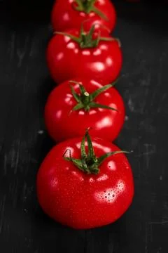 Tomato on a black background with realistic reflection and water drops. Fresh Stock Photos
