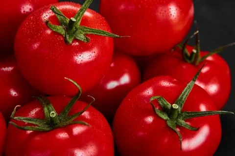 Tomato on a black background with realistic reflection and water drops. Fresh Stock Photos