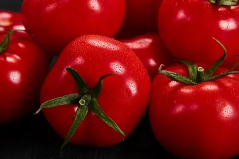 Tomato on a black background with realistic reflection and water drops. Fresh Stock Photos