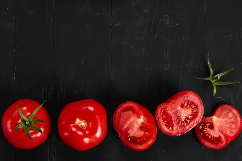Tomato on a black background with realistic reflection and water drops. Fresh Stock Photos