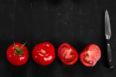Tomato on a black background with realistic reflection and water drops. Fresh Stock Photos