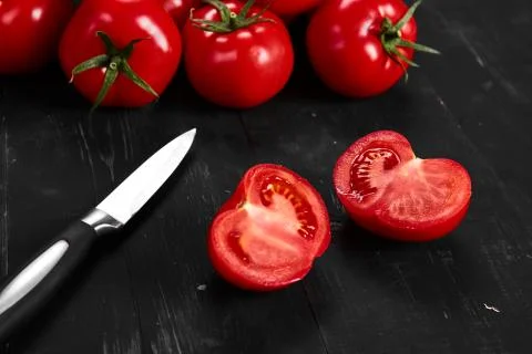 Tomato on a black background with realistic reflection and water drops. Fresh Stock Photos