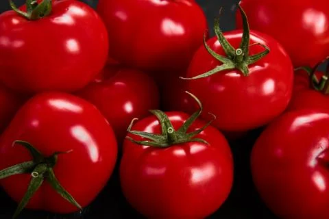 Tomato on a black background with realistic reflection and water drops. Fresh Stock Photos