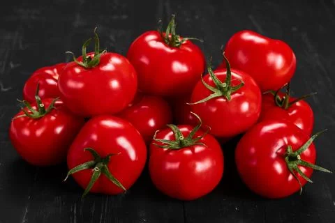 Tomato on a black background with realistic reflection and water drops. Fresh Stock Photos