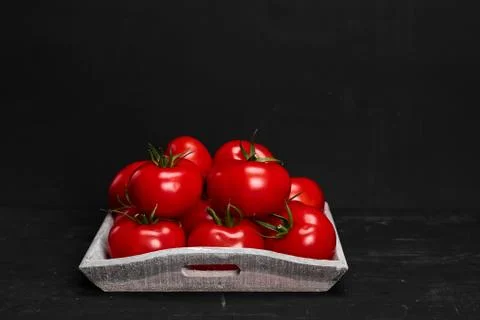 Tomato on a black background with realistic reflection and water drops. Fresh Stock Photos