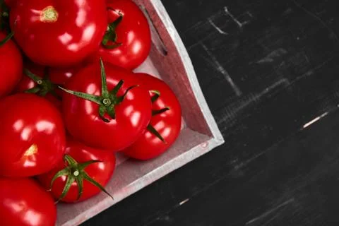 Tomato on a black background with realistic reflection and water drops. Fresh Stock Photos
