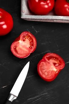 Tomato on a black background with realistic reflection and water drops. Fresh Stock Photos