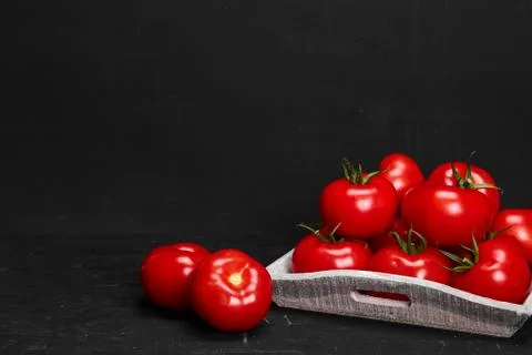 Tomato on a black background with realistic reflection and water drops. Fresh Stock Photos