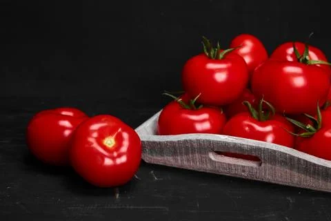 Tomato on a black background with realistic reflection and water drops. Fresh Stock Photos