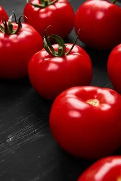Tomato on a black background with realistic reflection and water drops. Fresh Stock Photos