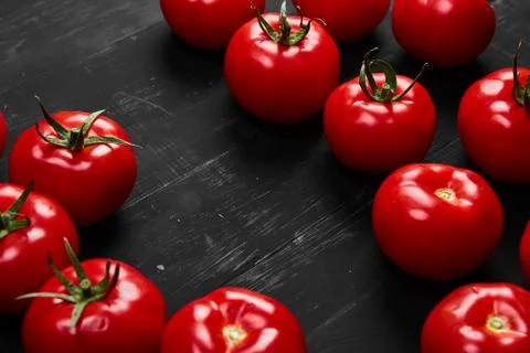 Tomato on a black background with realistic reflection and water drops. Fresh Stock Photos