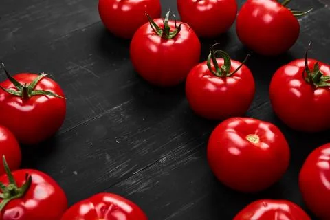 Tomato on a black background with realistic reflection and water drops. Fresh Stock Photos