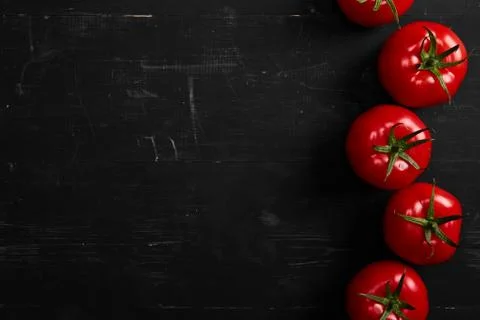 Tomato on a black background with realistic reflection and water drops. Fresh Stock Photos