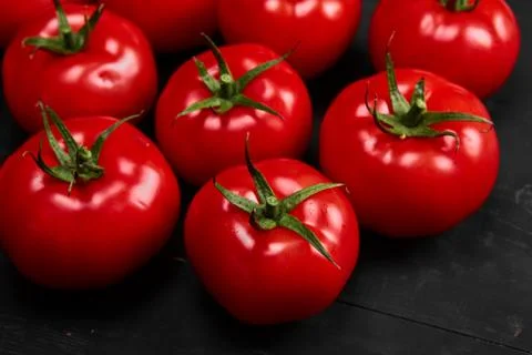 Tomato on a black background with realistic reflection and water drops. Fresh Stock Photos