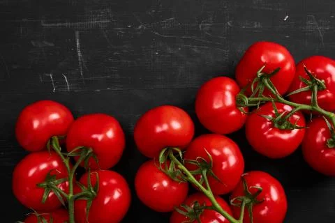 Tomato on a black background with realistic reflection and water drops. Fresh Stock Photos