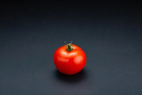Tomato on a black background with realistic reflection 스톡 사진