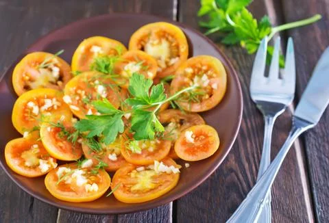 Tomato on board on a table Stock Photos