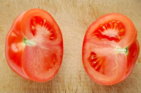 Tomato on brown wooden chopping board Stock Photos