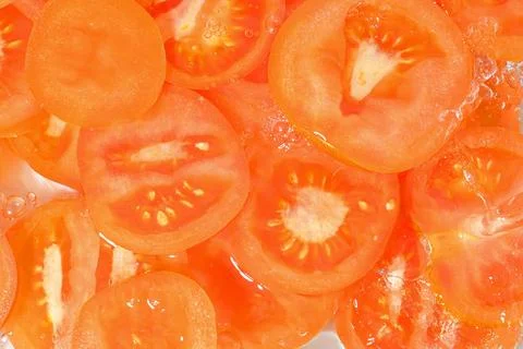 Tomato close-up in liquid with bubbles. Slices of red ripe tomato in water... 写真素材