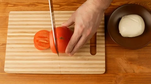 Tomato is cut with a knife at the level of the part, the top view. Stock Footage 108275733