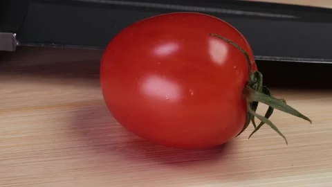 Tomato on a cutting board with a knife. Stock Footage 228245552