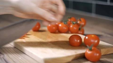 Tomato cutting closeup. Chef slices the cherry tomato. Knife, cutting Board Stock Footage 129537611