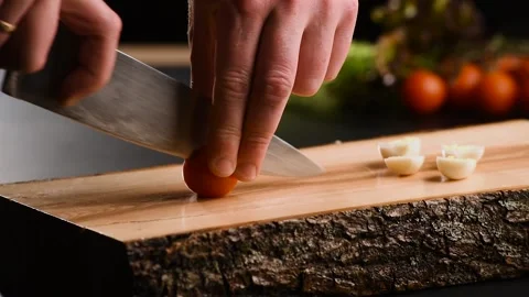 Tomato cutting closeup. Chef slices the cherry tomato. Knife, cutting Board Stock Footage 150395584
