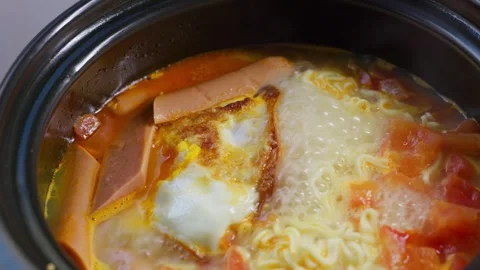 Tomato, egg and ham instant noodles being cooked in a pot Stock Footage 341492361