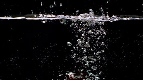 Tomato falling into water in slow motion. Isolated on black background. Close up Vídeo Stock 124833381