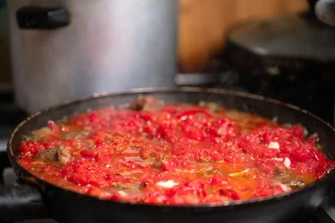 Tomato is fried in a pan Stock Photos