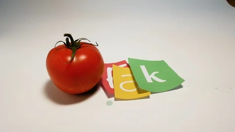 Tomato gmo on a white background and hand writing written fake made of newspaper Stock Footage 98640544