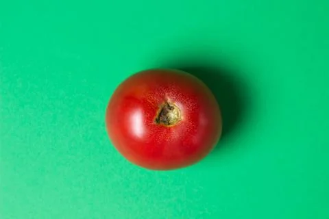 Tomato on a green background.  Stock Photos