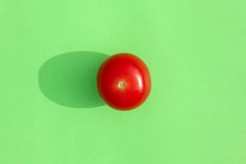 Tomato with a hard shadow on a colored background pattern Foto stock